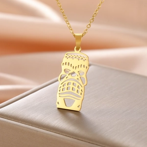 Détail d'un collier en acier inoxydable doré avec un pendentif de masque tribal