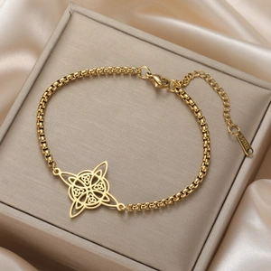 Close-up of golden stainless steel box chain bracelet featuring intricate Celtic knot charms