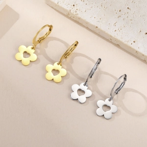 Détail des boucles d'oreilles fleurs polies en or et argent avec découpe en forme de cœur