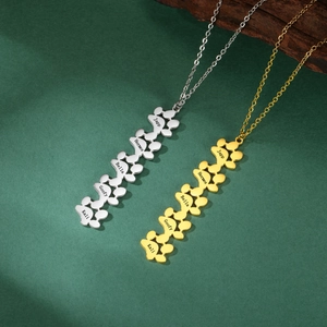 Detail van gepersonaliseerde poot-hanger ketting met namen gegraveerd op gepolijst metaal
