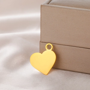 Macro view of 18K gold plated heart pendant with mirror finish on silk fabric