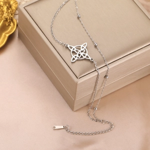 Silver stainless steel chain with intricate Celtic knot charm on a satin backdrop
