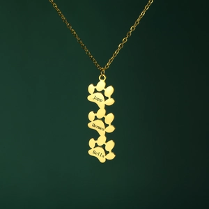 Detail van de gouden pootjesketting met drie gepersonaliseerde namen gegraveerd op hangers