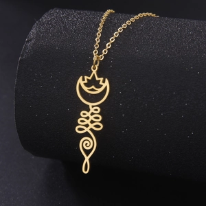 Macro detail of golden lotus Unalome pendant on a black textured jewelry display