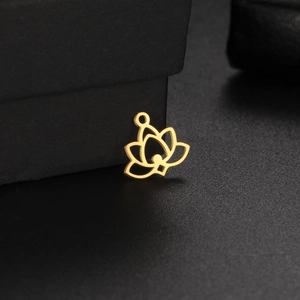 Détail d'un pendentif lotus doré ajouré sur fond texturé noir élégant