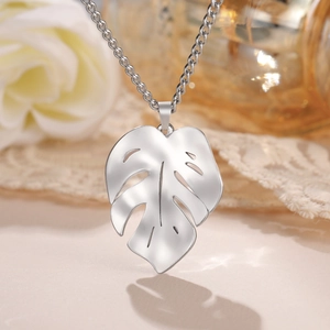 Elegante collana con ciondolo a foglia di monstera in acciaio inossidabile argento su sfondo