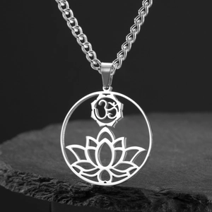 Macro shot of stainless steel lotus OM pendant on rock surface with detail texture