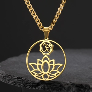Detailed macro view of the golden Om lotus yoga pendant on a black slate stand