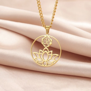 Detailed macro view of gold plated lotus and Om symbol pendant on champagne silk