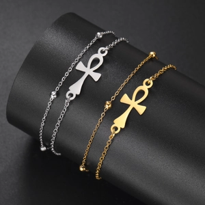 Titanium steel bracelet with gold and silver Ankh cross pendants on a jewelry stand