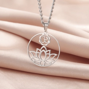 Macro shot of silver stainless steel Lotus OM yoga pendant necklace on silk fabric