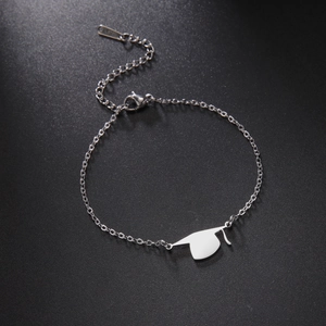 Macro shot of stainless steel graduation cap pendant with lobster clasp on black leather