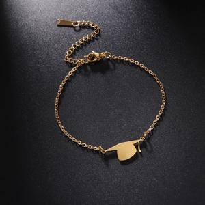 Macro detail of golden graduation cap charm on stainless steel chain bracelet