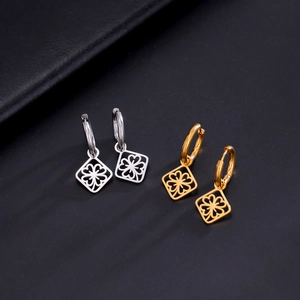 Detailed view of square clover charms on gold and silver stainless steel hoop earrings