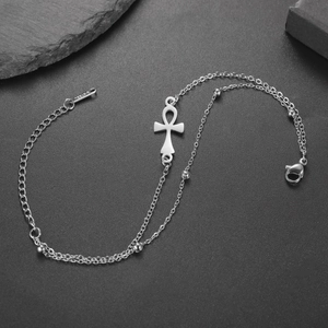 Close-up of polished stainless steel Ankh cross pendant and layered beaded chain detail