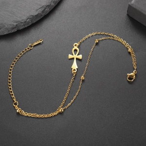 Macro shot of gold Ankh cross pendant bracelet showing S.STEEL stamp on lobster clasp