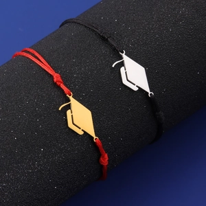 Detail of red and black woven graduation bracelets with gold and silver mortarboard charms
