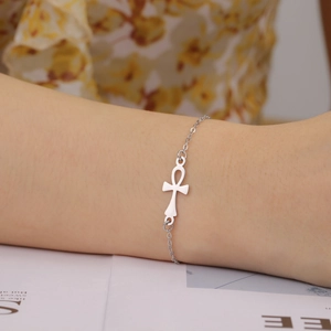 Silver stainless steel Ankh cross pendant bracelet on a woman wrist with a floral dress