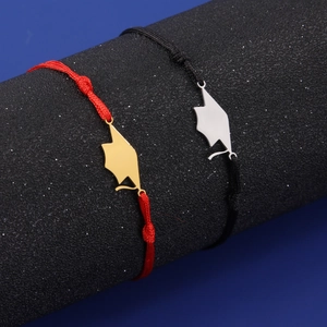 Detailed close-up of woven graduation bracelets with gold and silver doctoral cap pendants