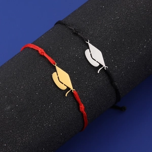 Detail of red and black woven cord graduation bracelets with polished mortarboard charms