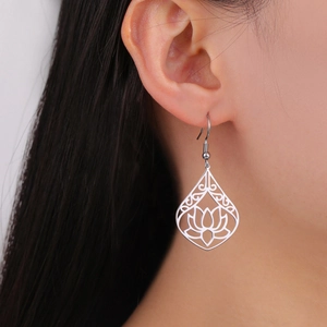 Detailed close-up of a hollow lotus flower charm earring worn on a model's ear