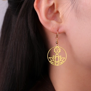 Detail of golden stainless steel hollow lotus earring with Om symbol on model ear