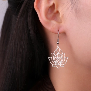 Detailed close-up of a silver stainless steel lotus flower drop earring on a female model