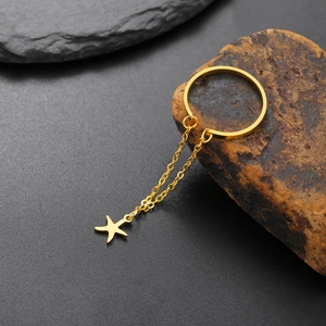 Elegante anello aperto dorato con catena a nappa con stella su una pietra naturale