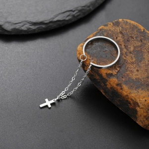 Dettaglio anello aperto argento con catenelle sottili e ciondolo a croce su pietra