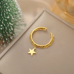 Dettaglio dell'anello dorato con stella pendente e catenina su una scatola regalo