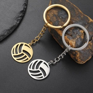 Polished stainless steel volleyball keychains in gold and silver on stone