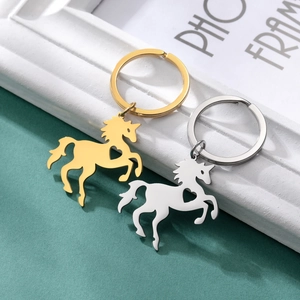Unicorn keychain in gold and silver finish with hollow heart detail on green base