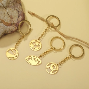 Detailed close-up of golden stainless steel keychains in basketball and soccer ball shapes