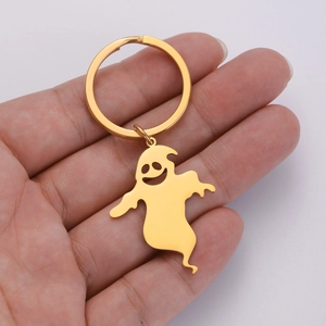 Detail of hand holding a polished gold 304 stainless steel ghost keychain pendant