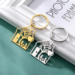 Detail of house-shaped stainless steel keychains in gold and silver with family silhouettes