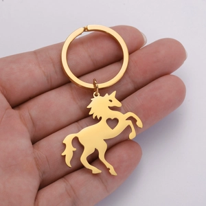 Close-up of golden unicorn keychain with heart cutout held in hand for detail