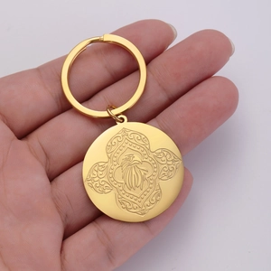 Detailed close-up of golden stainless steel keychain with eagle emblem held by hand