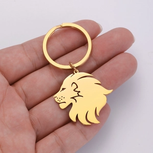 Close-up of a gold-plated stainless steel lion head pendant keychain held in hand