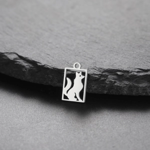 Detailed macro view of a rectangular silver steel pendant with an intricate wolf cutout