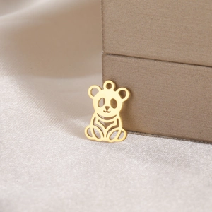 Macro view of a gold panda pendant with minimalist hollow design on silk texture