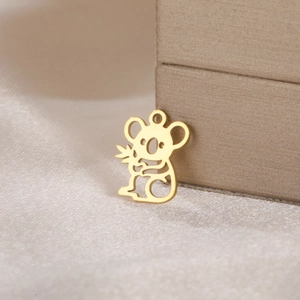 Detailed macro of a hollow koala pendant in gold-plated stainless steel on white satin