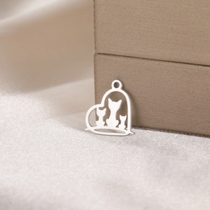 Macro detail of cat silhouettes in a heart-shaped stainless steel jewelry pendant