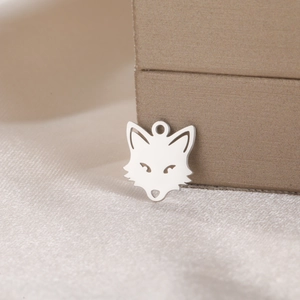 Polished stainless steel fox pendant displayed on silk fabric for DIY jewelry making