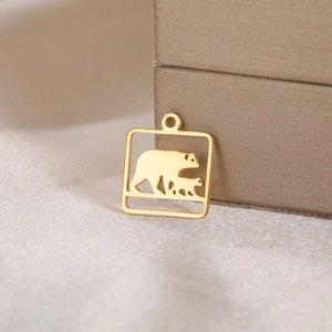 Detail showing a golden square cutout pendant with a mother and child bear motif