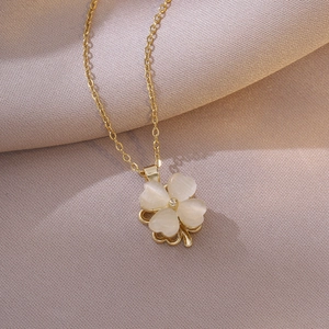 Collier trèfle doré avec pierre œil de chat blanche sur fond en soie élégant