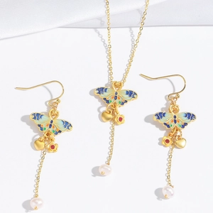 Macro view of butterfly jewelry set with enamel wings and white freshwater pearl drops