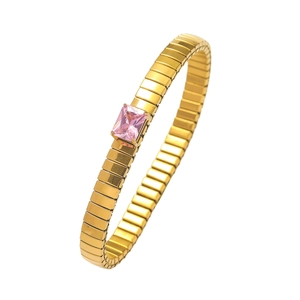 Detail of gold bracelet featuring pink rectangular gemstone and segmented band
