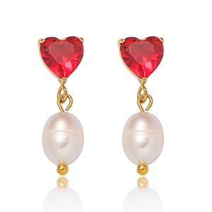 Détail des pierres rouges en cœur et perles d'eau douce sur boucles d'oreilles dorées