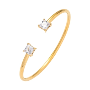 Detailopname van gouden open armband met vierkante prinsesgeslepen zirkonia edelstenen