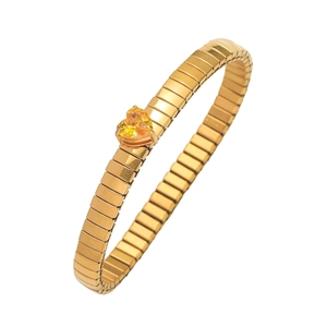 Detail eines goldenen Armbands mit herzförmigem gelbem Edelstein und Gummiband